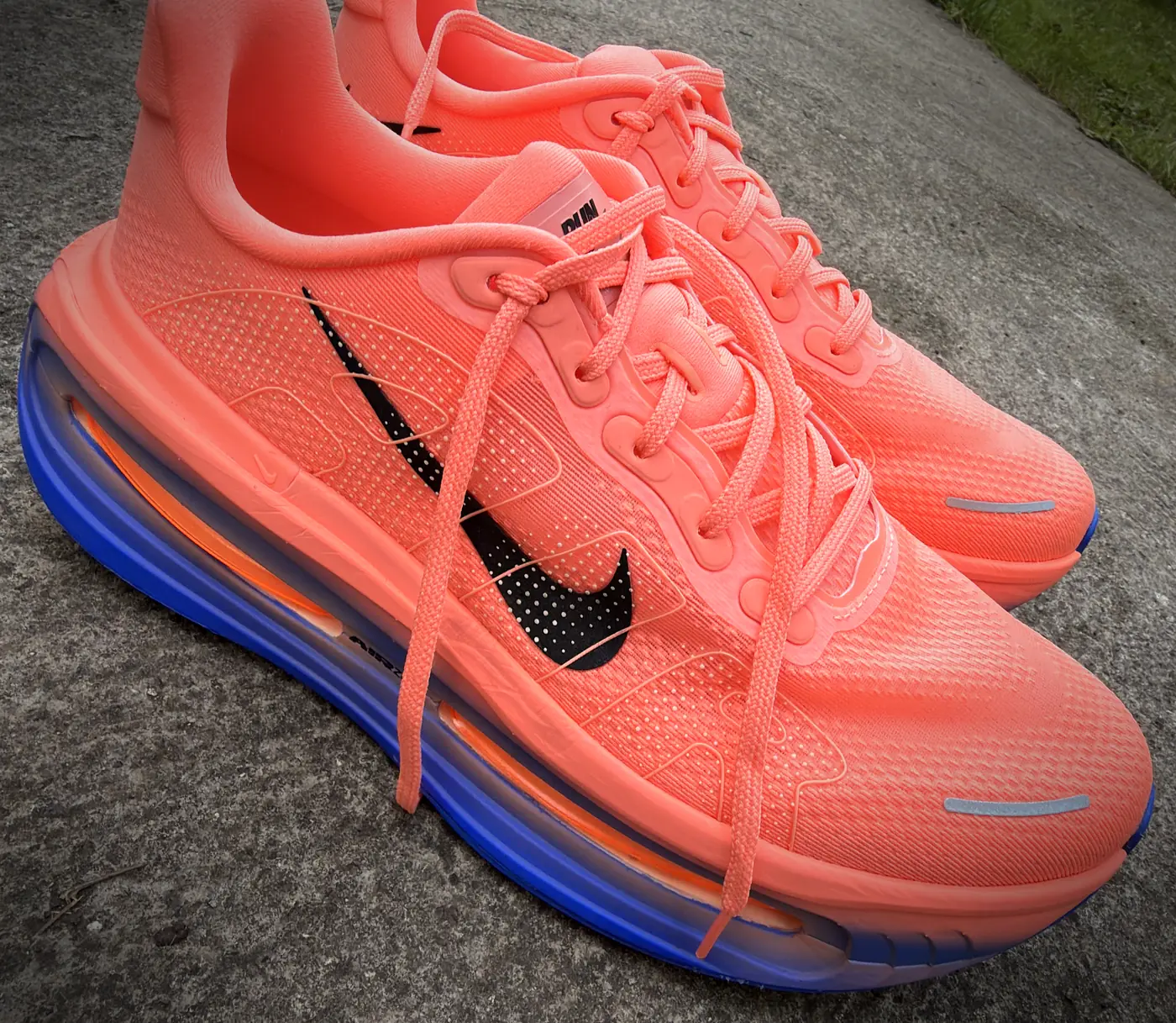 A pair of Nike Vomero Premium running shoes in coral with a translucent blue midsole